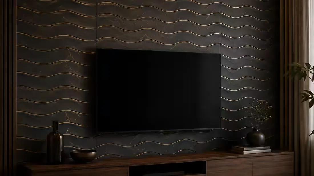 A living-room TV feature wall clad in dark charcoal panels with a carved wave relief and fine gold inlay lines, above a wooden media unit.